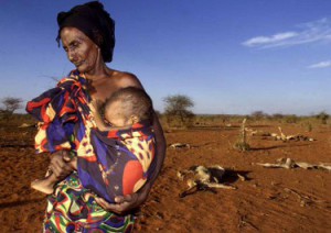 PHOTOS DE FIN D'ANNÉE 2000 - Ruqia Aroo, 80, porte son petit-fils malnutri Khalif Sheikh Adan, 5, près des carcasses de son troupeau de bovins morts près d'Afder, 1100 km au sud-est d'Addis-Abeba, avril 18, 2000. (CANADA SORTIE) gm/Photo de George Mulala REUTERS
